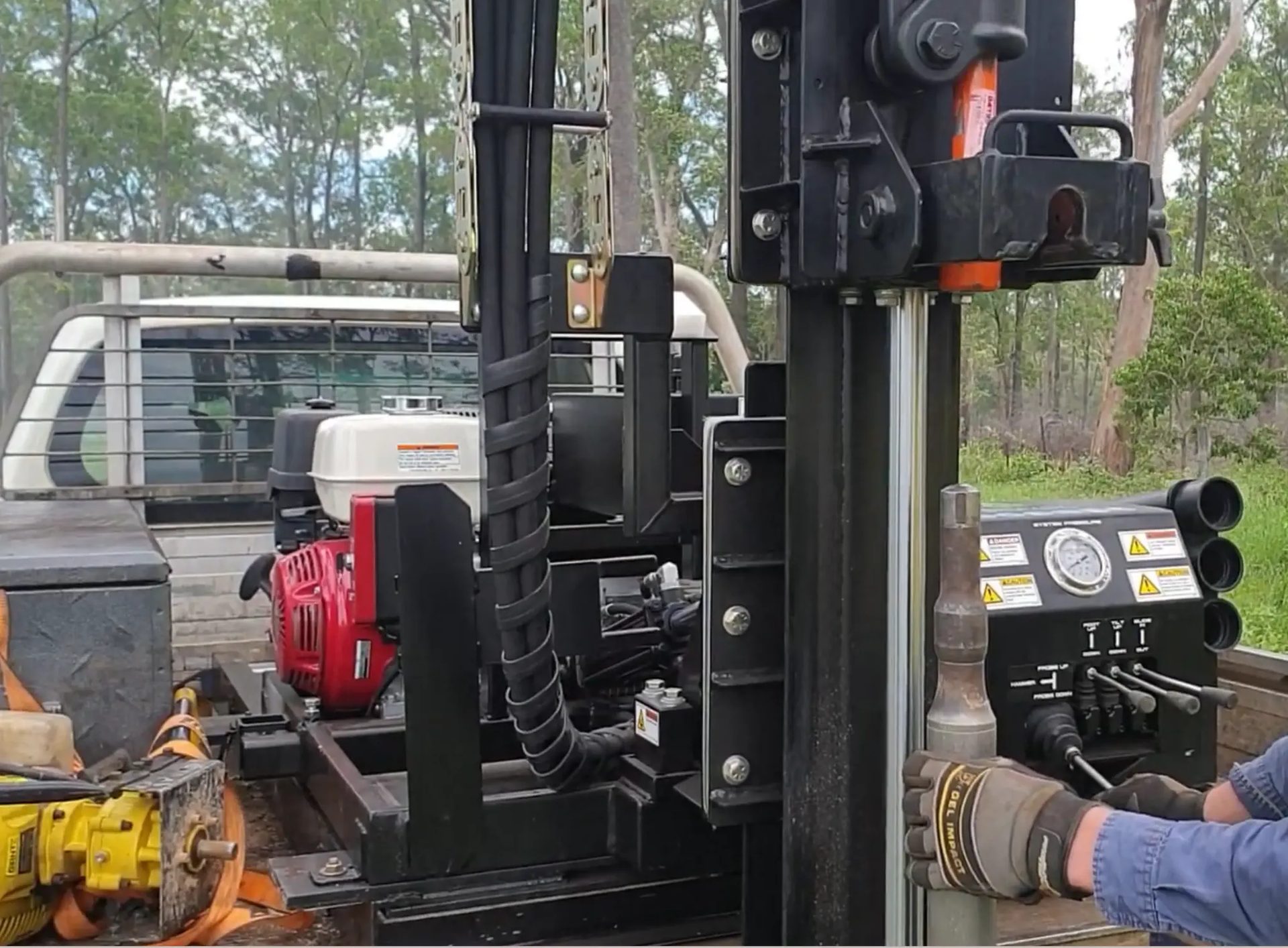 Field technician operating soil drilling rig on site
